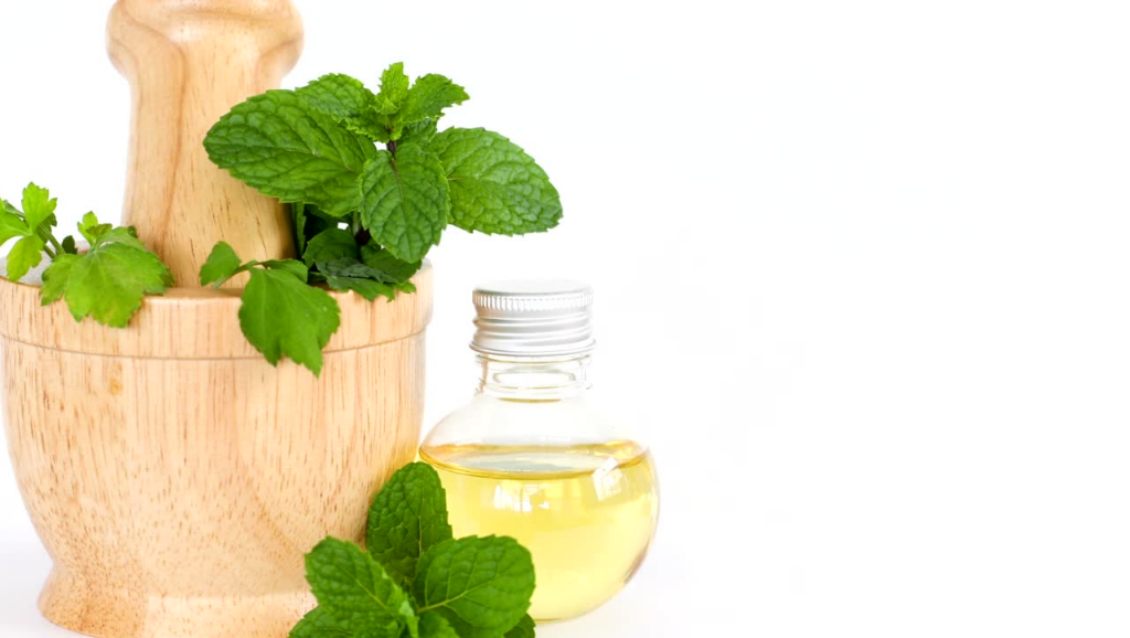 Matcha being poured in a cup, with the bamboo whisk next to it and the matcha package in the back