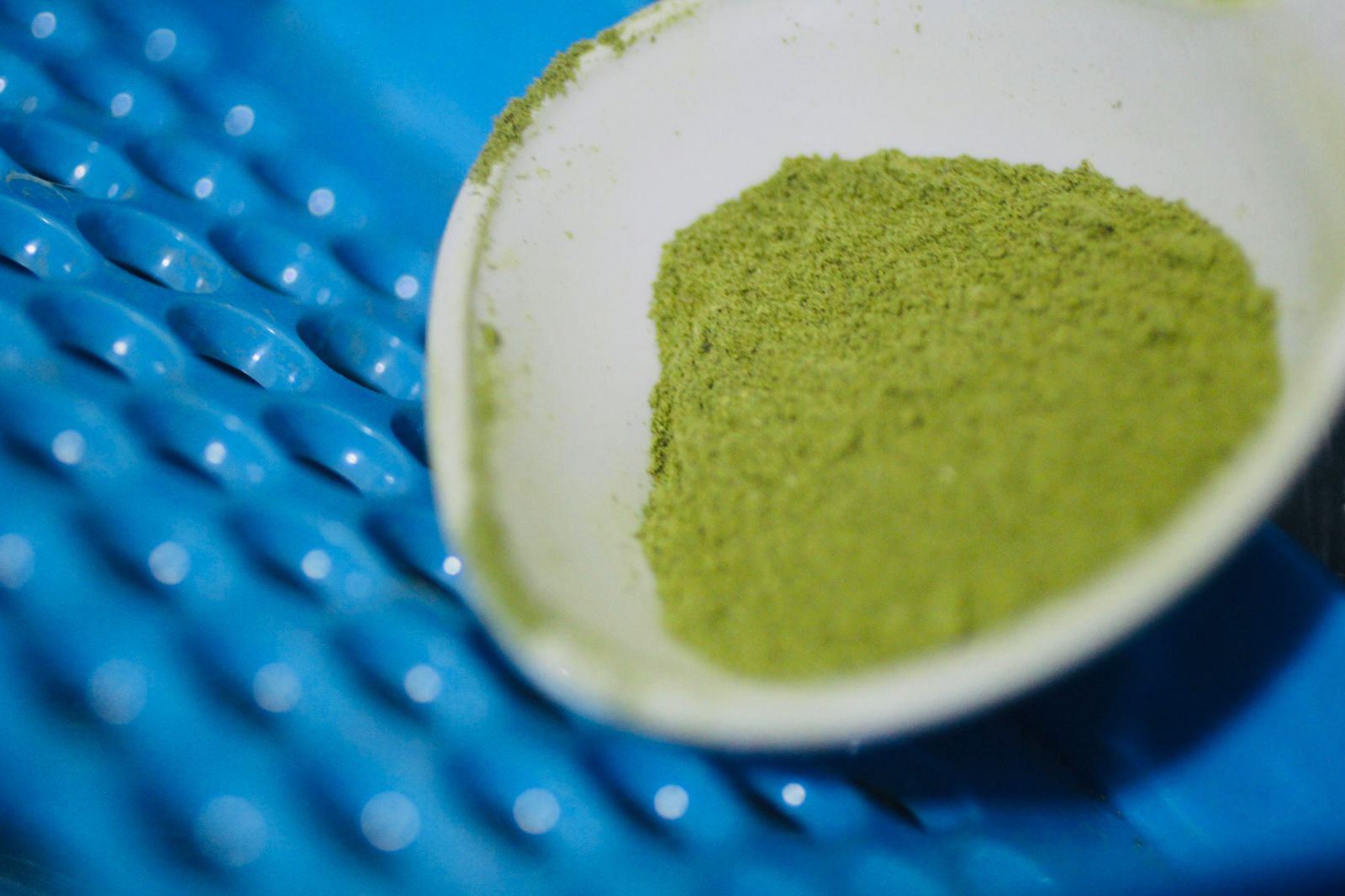 Close up of organic matcha powder on a wooden spoon